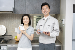 電卓を持った女性と作業着の男性の写真